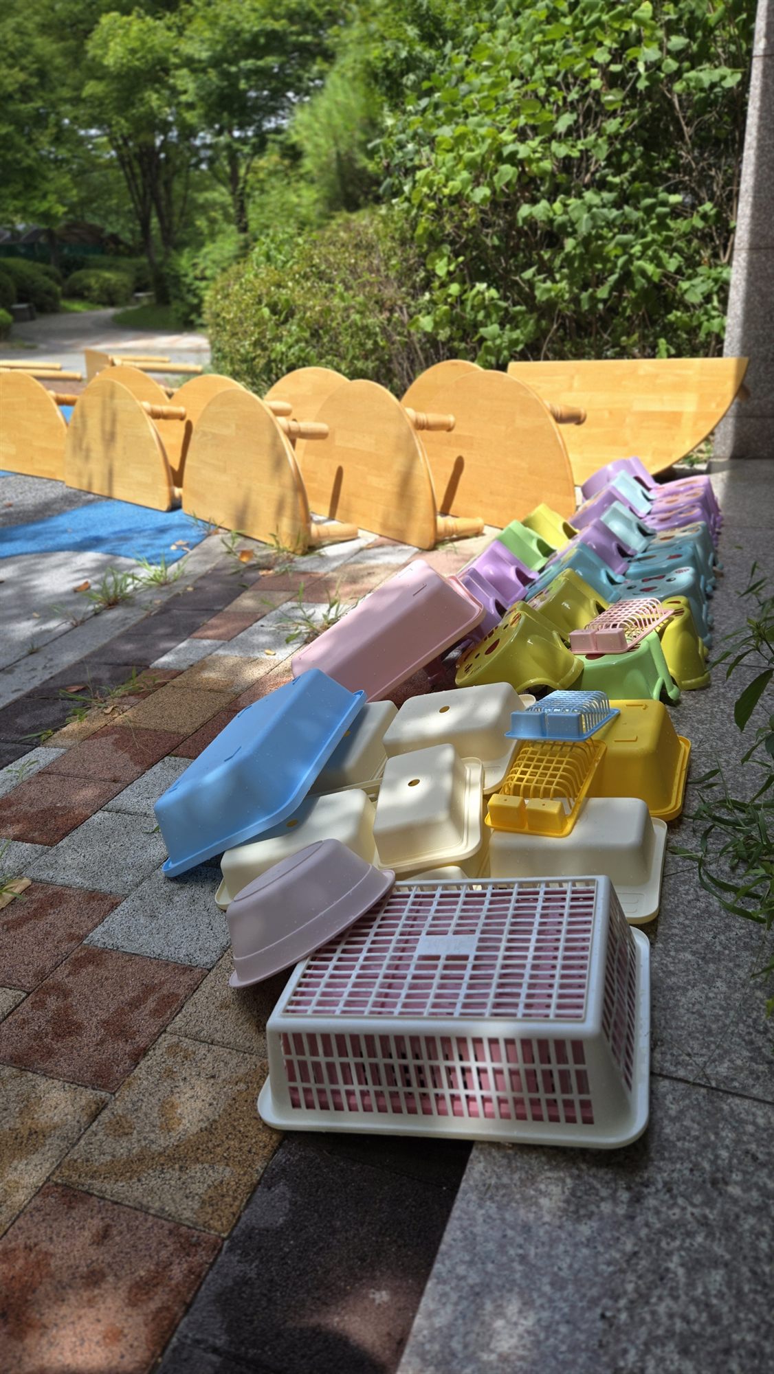 햇볕에 나란히 널어 말리는 아이 의자와 놀이 교구